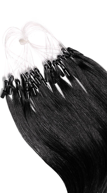 Nahaufnahme einzelner Microring-Strähnen in Schwarz, glänzendes Remy Echthaar – Rubin Extensions®