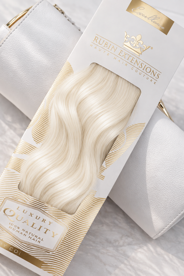 Rubin Extensions Tape-in Excellence Line in Platinblond, mit seidigen Wellen in einer weiss-goldenen Verpackung.