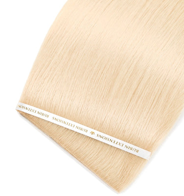 Nahaufnahme der glänzenden Echthaarsträhnen in Honigblond, Genius Weft Tresse – Rubin Extensions®