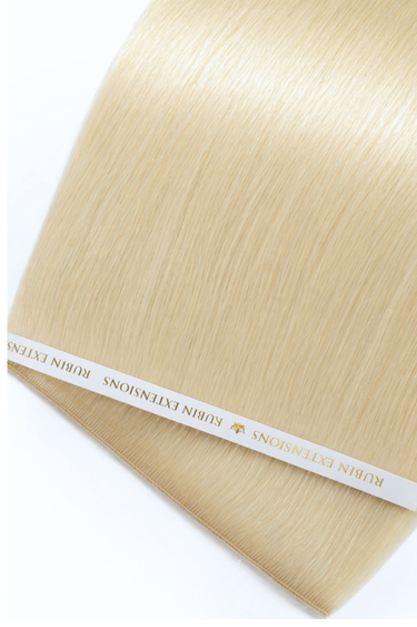 Nahaufnahme der glänzenden Echthaarsträhnen in Goldblond, Genius Weft Tresse – Rubin Extensions®