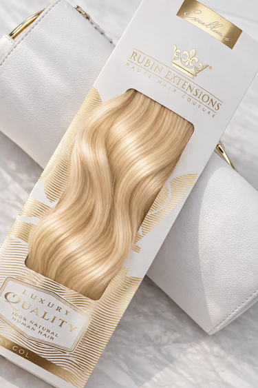 Rubin Extensions Tape-in Excellence Line in Honigblond, mit seidigen Wellen in einer weiss-goldenen Verpackung.
